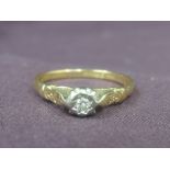 A lady's dress ring having a diamond solitaire in an illusionary setting to raised shoulders on