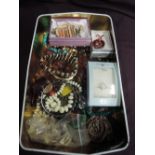 A tin of costume jewellery including pendants, bangles etc