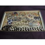 A tray of costume jewellery including metal pendants, diamante pendant, simulated pearls etc