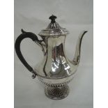 An silver coffee pot of circular form having gadrooned decoration, hard wood handle and pedestal