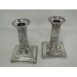 A pair of Victorian silver candlesticks of column form with removable sconces and square bases, (