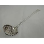 A Georgian silver soup ladle having shell formed bowl and feather edging to handle with plain