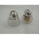 A pair of cut glass pepperettes having domed silver lids, Birmingham 1912, William Vale & Sons