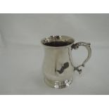 A Georgian silver tankard/mug of plain baluster form on stepped pedestal foot and with leaf topped