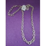 A silver necklace having loop and bar clasp and heart charm, and a fancy link white metal bracelet