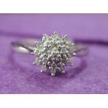 A lady's dress ring having a diamond chip triple cluster on a 9ct white gold loop, size L