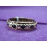 A lady's full eternity ring having diamond and sapphire chip decoration on a yellow metal loop, size