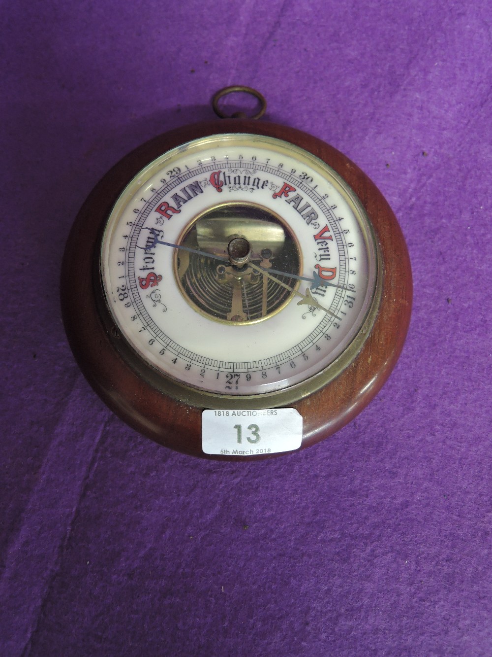 A vintage barometer in bulls eye design and enamel face
