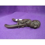 A vintage treen nut cracker in a black forrest style marked chillon