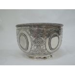 A Victorian silver sugar bowl having repousse foliate and star decoration, plain cartouches and