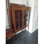 An Edwardian mahogany display cabinet having band and inlay decoration on slender tapered legs