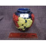 A Moorcroft vase of ginger jar design having hibiscus pattern on blue ground