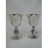 A pair of silver goblets having inverted bell shaped bowls with gilt interiors on stems having