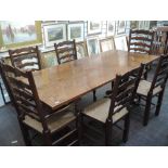 A reproduction oak refectory table and set of six (4+2) ladder back chairs having rush seats