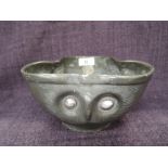 A late 19th/early 20th century pewter bowl of wave triform design having owl face decoration,