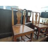 A pair of early 19th century elm vernacular chairs having vase splats with solid seats on square