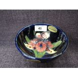 A Moorcroft bowl having orchid pattern on blue ground, with label