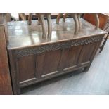 An 18th century oak kist/coffer having plank top and carved and panel front on stile frame