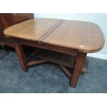 An early 20th century mahogany drawer leaf dining table having heavy square legs and X frame base,