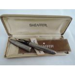 An American silver fountain pen by Sheaffer having chequered decoration and yellow metal nib stamped
