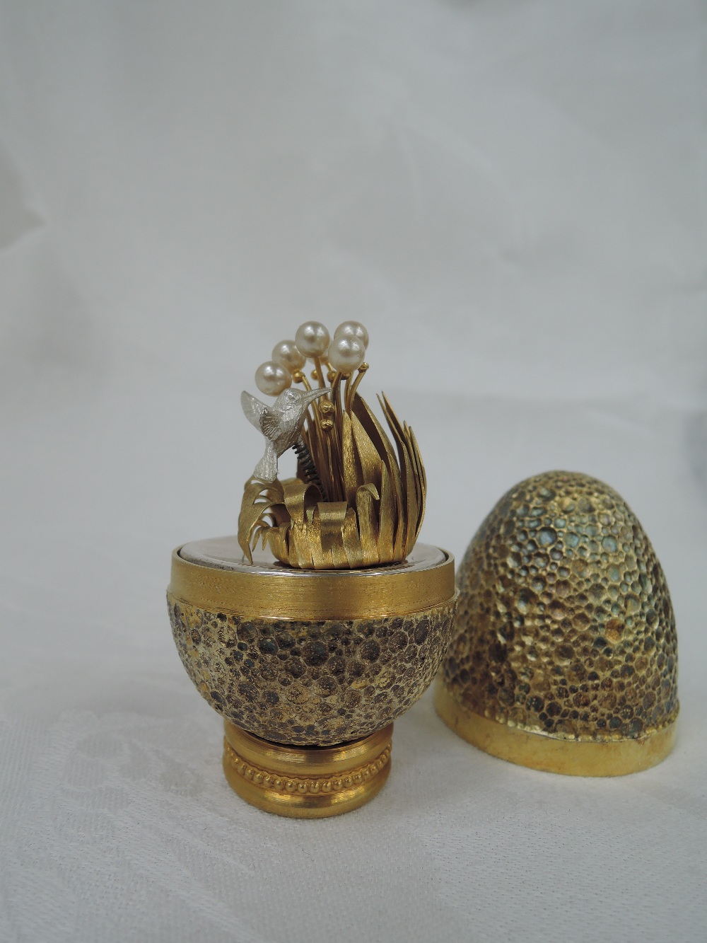 A cased Stuart Devlin 1978 silver gilt limited edition surprise Easter egg having a textured mottled