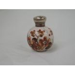 A Victorian painted porcelain scent bottle of spherical form having floral decoration and a silver