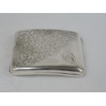 A silver cigarette case of curved rectangular form having engraved scroll decoration with D monogram