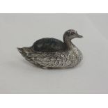 An Edwardian silver pin cushion modelled as a duck with ruby set eyes and blue pad, Birmingham 1908,