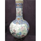 A 19th century Cantonese bottle vase having famille rose pictorial panel decoration, on hardwood