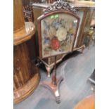 A Victorian rosewood pole screen having adjustable panel with embroidered decoration on turn