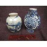 A 19th century Chinese blue and white moon flask having naturalistic decoration and a similar period
