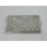 A white metal cigarette case having scroll and floral engraved decoration and plain cartouche,