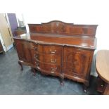 An early 20th century dark mahogany sideboard in the Chippendale revival style having raised back