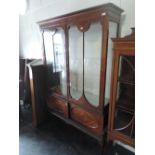 An early 20th century mahogany display cabinet having double glass doors over double cupboard or