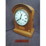 An Edwardian oak mantel clock, having arch top with inlay decoration with circular Roman numeral