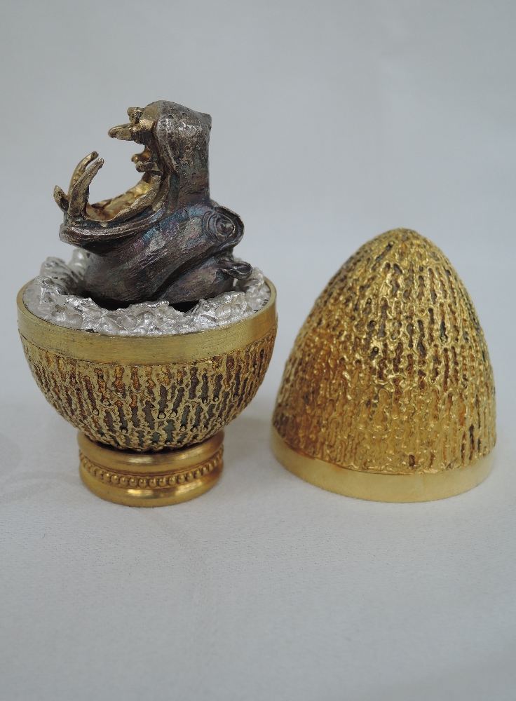 A cased Stuart Devlin 1974 silver gilt limited edition surprise Easter egg having a textured