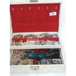 A jewellery box containing a selection of costume jewellery including simulated pearls, brooches,