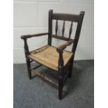 A late 19th century stained frame child's armchair having spindle back with ratten seat and turned