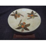 A Charlotte Rhead charger, having brown tube lined floral decoration on cream ground S/5982