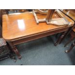 A 19th century mahogany tea table having fold over swivel top on turned legs