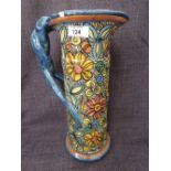 A mid 20th century earthenware jug of stylised form having painted floral decoration, marked to base