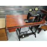 A vintage singer sewing machine with industrial cast base and table