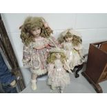 A selection of vintage ceramic head and soft bodied dolls with Sunday dress ware