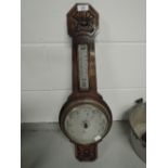 A vintage wall mounted banjo style barometer with carved decoration