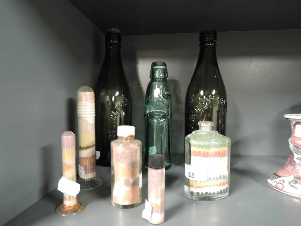 A selection of decorative sand art and vintage bottles