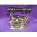 An antique brass cast coal iron with treen handle