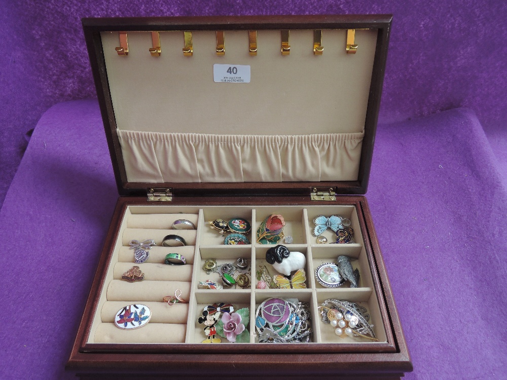 A wooden jewellery box containing a selection of brooches, rings, pins etc