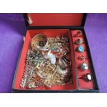 A jewellery box containing a selection of gold plated costume jewellery including fashion rings,