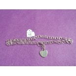 A silver bar and link necklace having a plain heart shaped charm