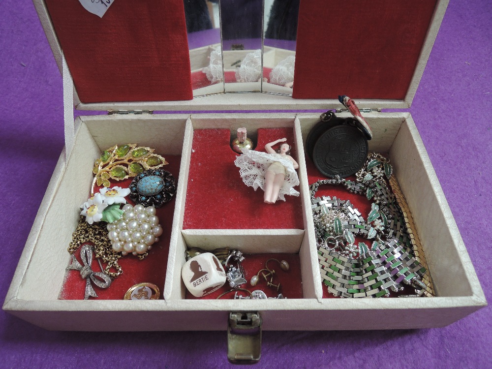 A vintage jewellery case containing a small selection of costume jewellery